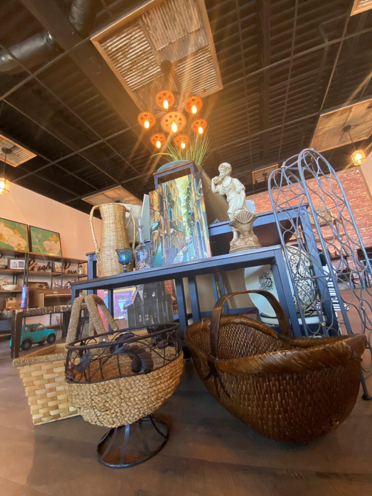 Picture of inside of ReFind store that shows large light fixture, backets and other homegoods decor. 