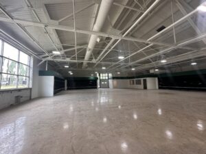 Inside photo of future grocery store. White industrial ceilings showcasing the future produce section and cooking classroom.